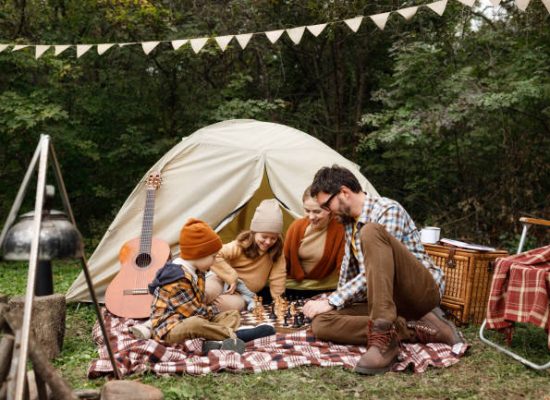 family enjoying board game on camping