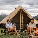 friends enjoying camping with bell tent in beautiful nature and mountains