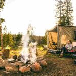 woman enjoying camping beside campfire
