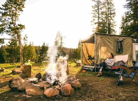 woman enjoying camping beside campfire