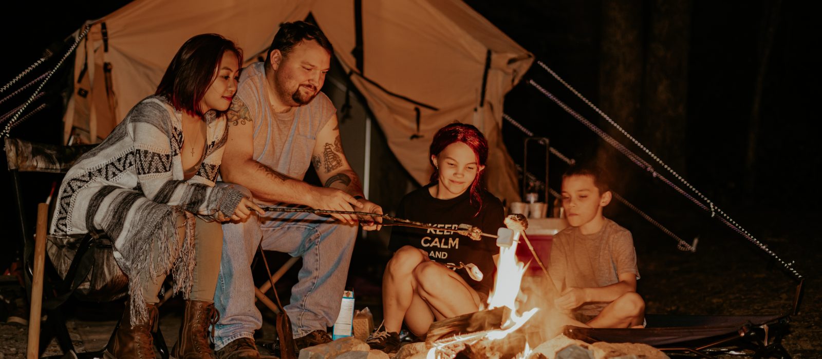 family enjoying campfire at night