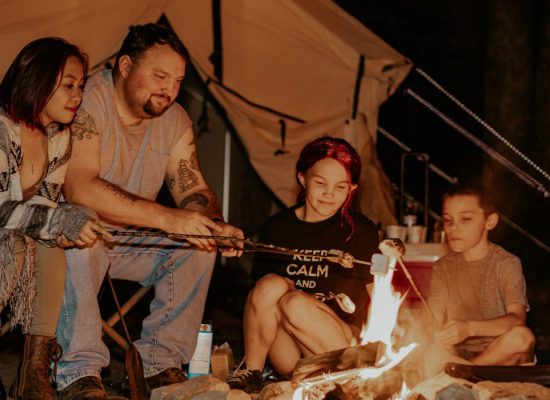 family enjoying campfire on camping