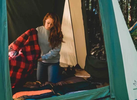 women setting up the tent to make it cozy