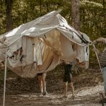 family setting up the wall tent for camping