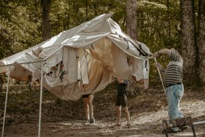 family setting up the wall tent for camping