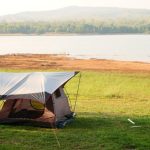 beautiful tent setup with canvas tarp near the lake