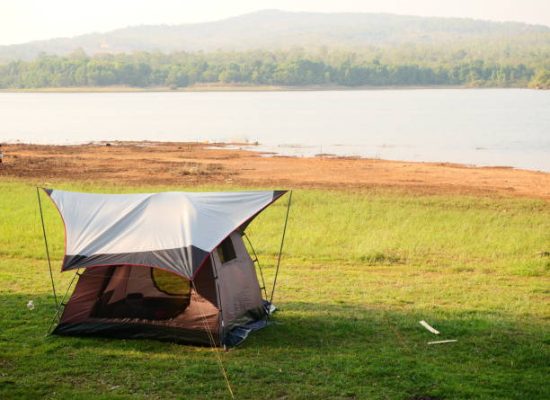 beautiful tent setup with canvas tarp near the lake