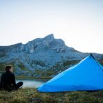 man enjoying breathtaking view of mountains during solo camping