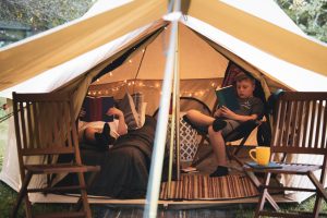 kids reading books inside the camping tent