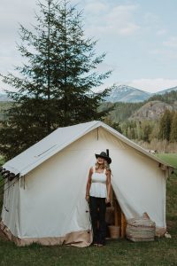 women standing in front of the wall tent on outdoor adventure