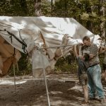 kids setting up tent with father for family camping
