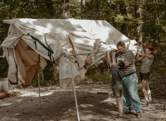 kids setting up tent with father for family camping