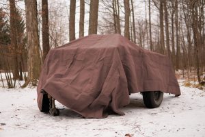 truck covered with tarp in snow