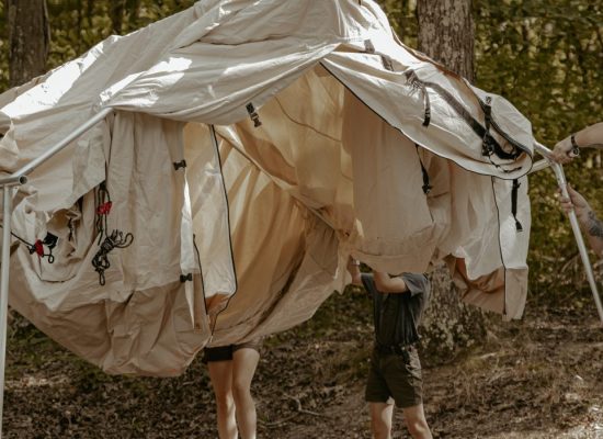 family setting up a canvas wall tent for camping adventure