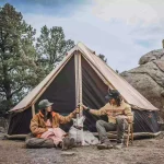 girls enjoying camping in nature with canvas tent