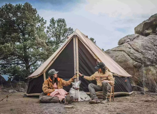 girls enjoying camping in nature with canvas tent