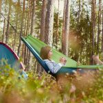 girl enjoying hammock camping in forest