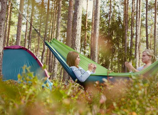 girl enjoying hammock camping in forest