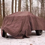 truck protected with canvas tarp from snow on camping
