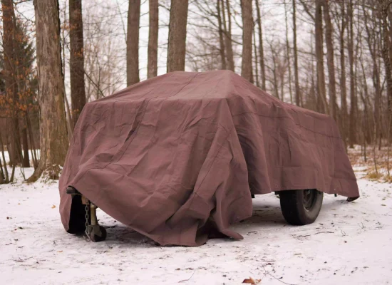 truck protected with canvas tarp from snow on camping