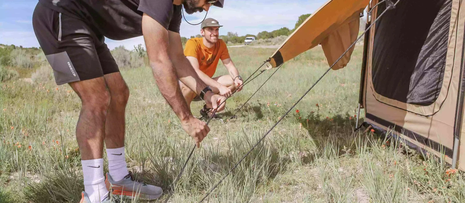 boys staking the canvas tent for camping adventure