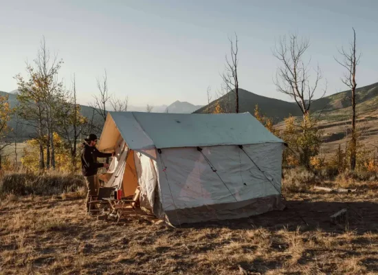 Wall tent setup for camping in nature behind mountains