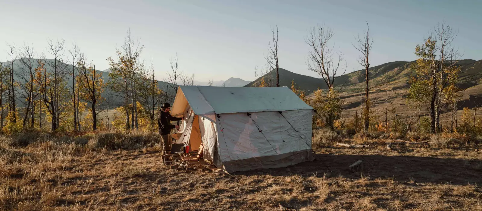 Wall tent setup for camping in nature behind mountains
