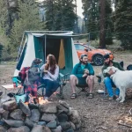 friends enjoying outdoors with campfire in forest