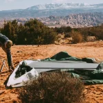 man repairing canvas tent