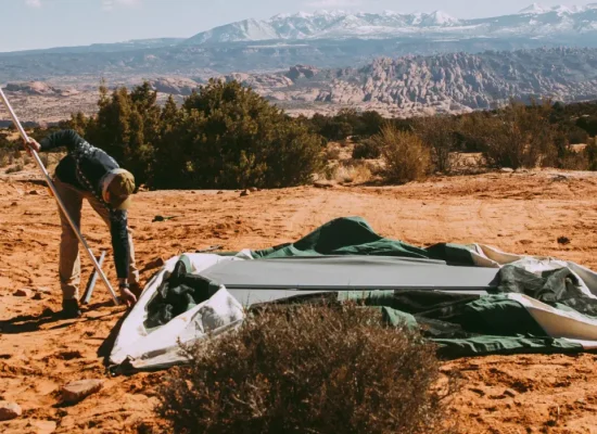 man repairing canvas tent