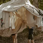 family sealing their canvas tent seam for smooth camping experience