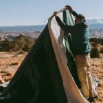 man packing the bell tent after camping