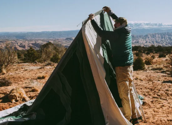 man packing the bell tent after camping