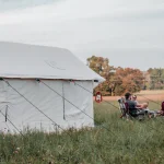 friends enjoying camping in summer with wall tent