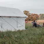 family and friends enjoying outdoors with family camping tent in plains