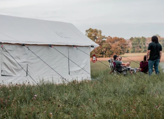 family and friends enjoying outdoors with family camping tent in plains