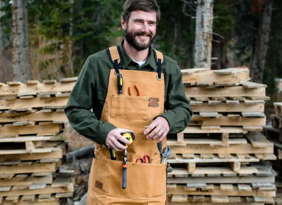 man working in outdoors with canvas working apron