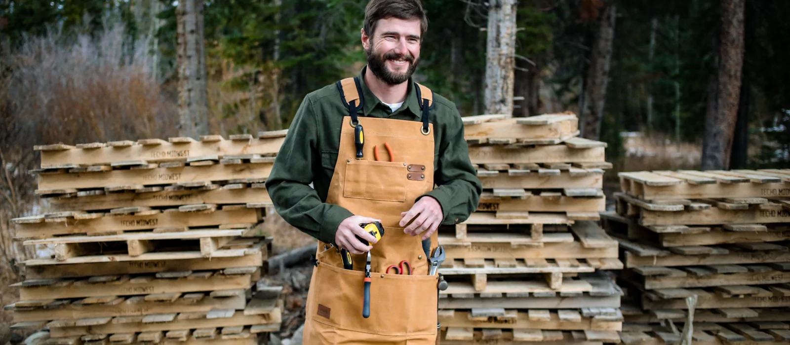 man working in outdoors with canvas working apron