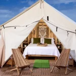 wall tent setup with bed for sleeping near the beach