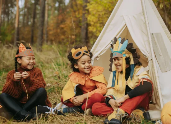 children enjoying halloween camping party and wearing costumes
