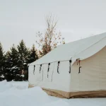 Wall tent in a snowy landscape at dusk