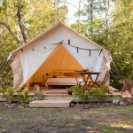 canvas wall tent setup in forest for family camping