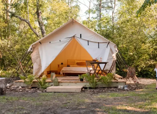 canvas wall tent setup in forest for family camping