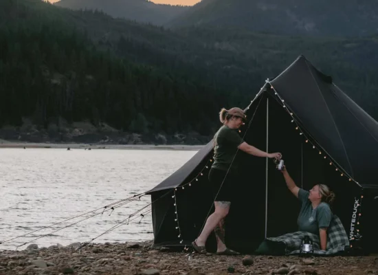 friends enjoying bell tent camping near the lake and mountains