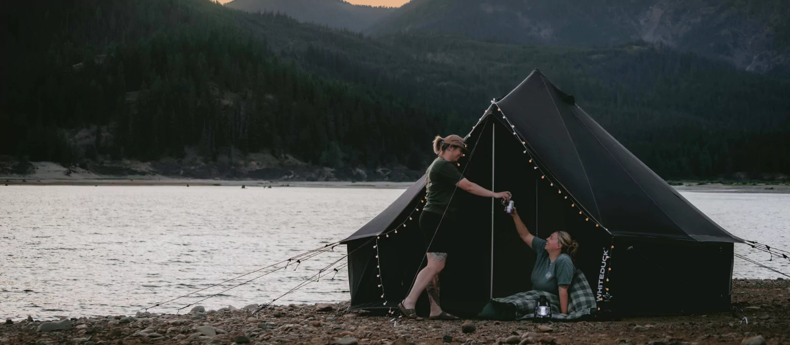 friends enjoying bell tent camping near the lake and mountains