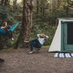 couple sharing campfire stories on camping in forest