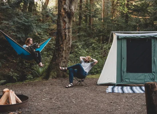 couple enjoying outdoor camping in forest with cabin tent