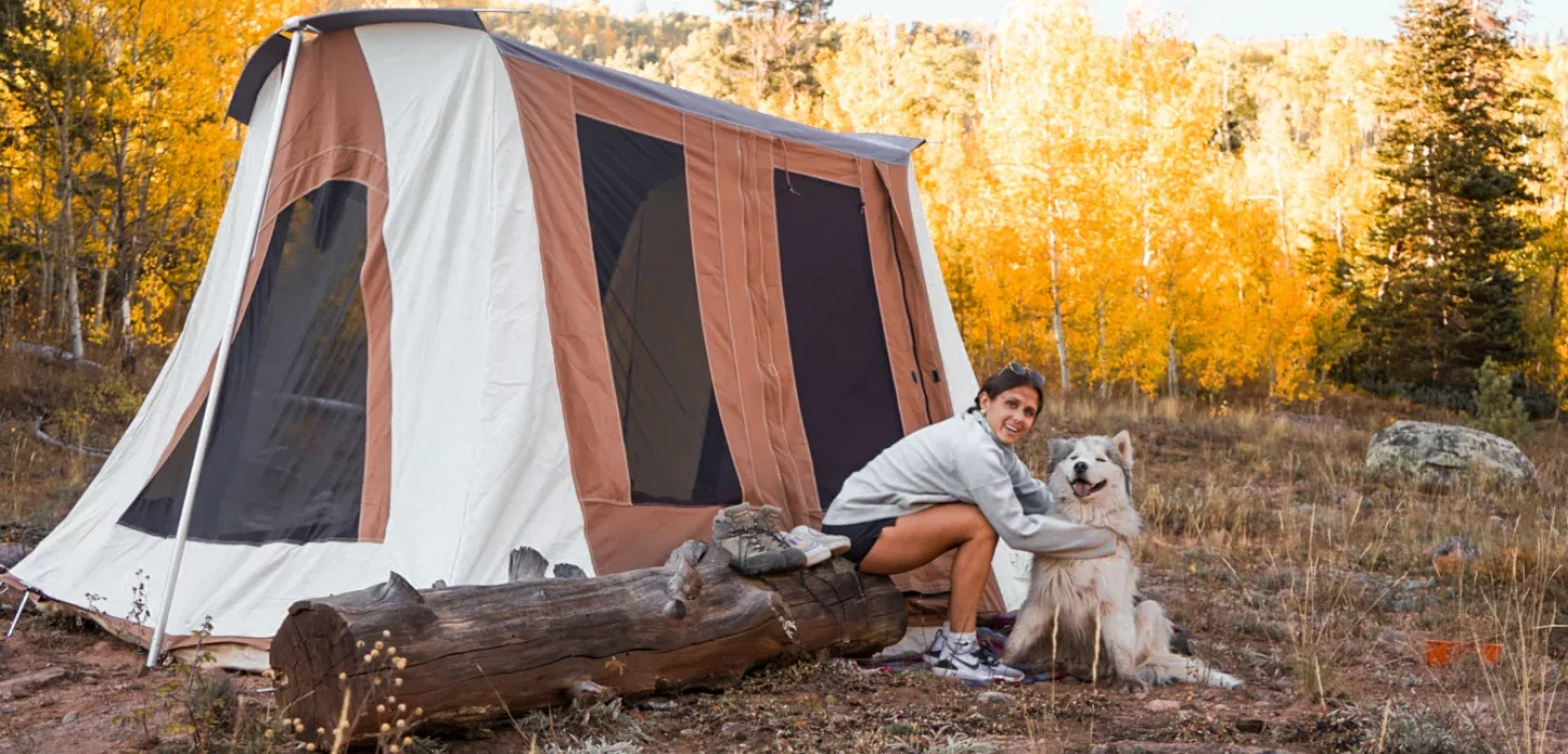 girl enjoying outdoors with dog using cabin tent