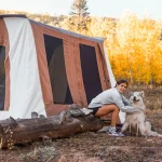 girl enjoying outdoors with dog using cabin tent