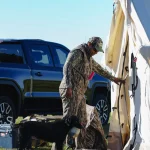 hunting camp with wall tent and dog